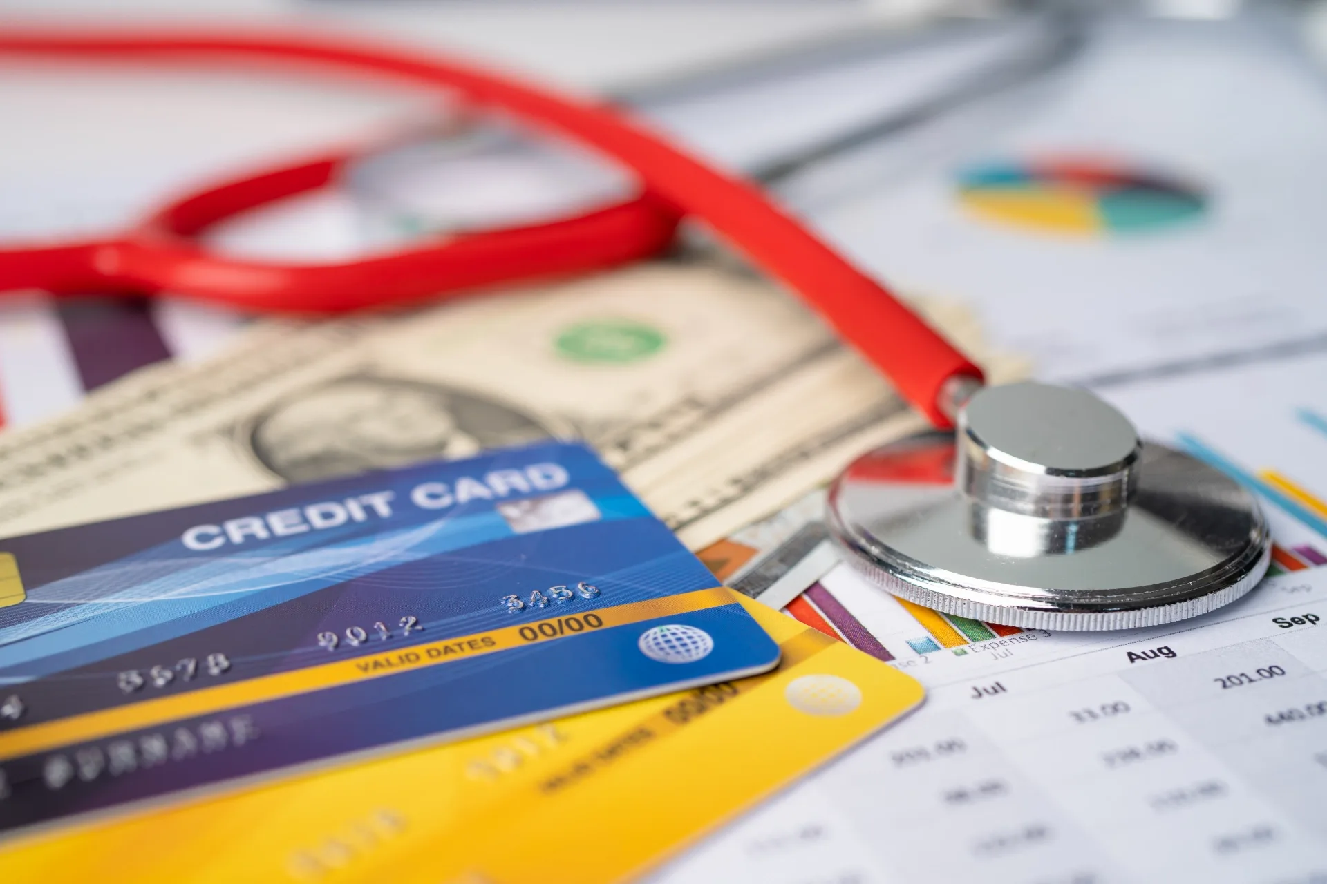 A stethoscope beside payment cards and financial documents